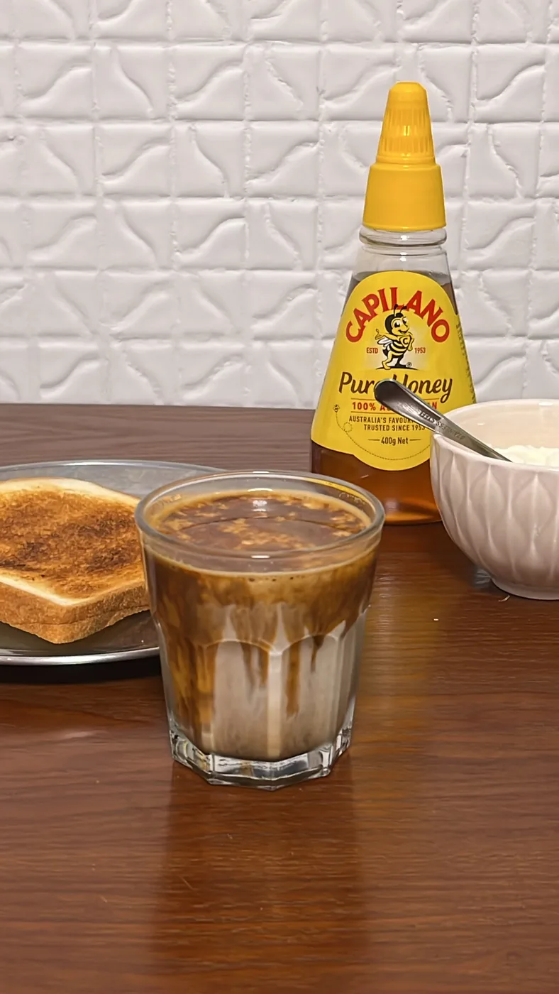 A dirty coffee with toast and honey